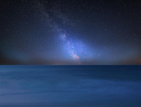 Vibrant Milky Way Composite Image Over Landscape Of Calm Sea Loo