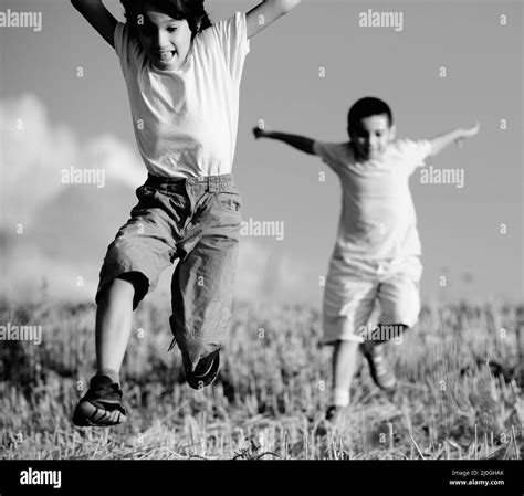 Two Little Boys On Field Running Together Stock Photo Alamy