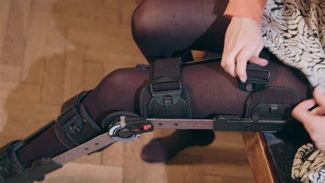 Detail Of The Lower Half Of A Lady Adjusting A Supportive Leg Brace