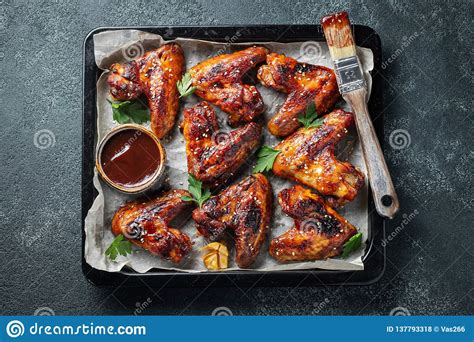 Roasted Chicken Wings In Barbecue Sauce With Sesame Seeds And Parsley