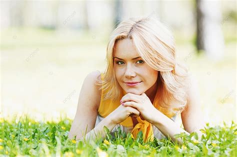 Smilng Happy Young Woman Lying On Green Grass Meadow Background And