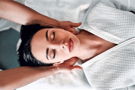 Beautiful Young Woman Receiving Facial Massage With Closed Eyes In A Spa Salon Stock Image