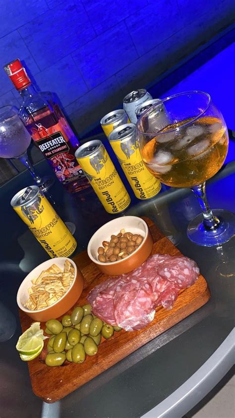 a table topped with different types of food and drinks on top of a wooden cutting board