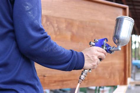 Hands Of Industrial Worker Holding Spray Paint Gun In The Workshop