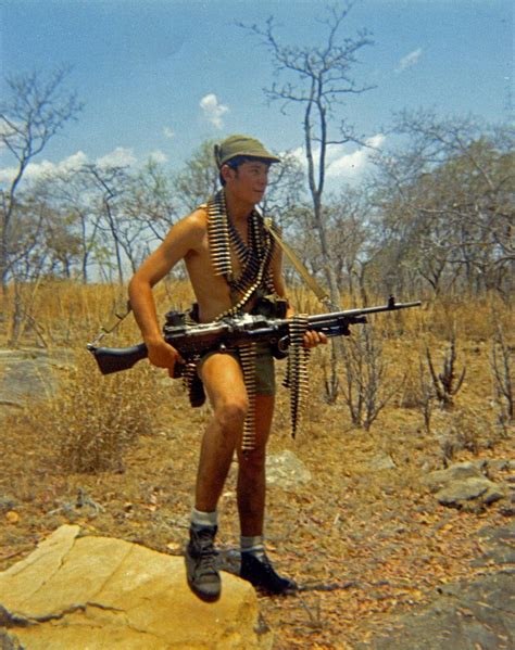 A Rhodesian Soldier Wearing Short Shorts And Holding Fn Mag Machine Gun