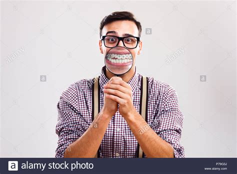 Nerdy Man Is Showing His Braces With Magnifying Glass Stock Photo Alamy