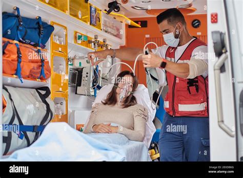 Paramedic Putting Ventilator Mask To Patient Lying On Medical Stretcher