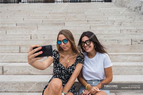 Laughing Women Taking Selfie On Stairs At Old Building — District