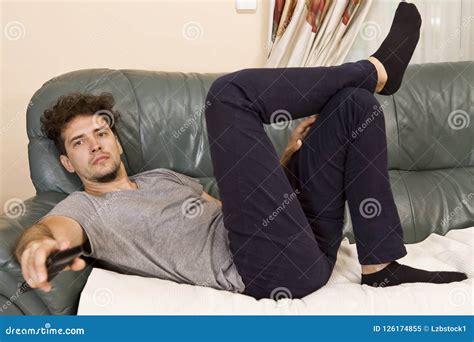 Lazy Man Con El Telecontrol En El Sofá Imagen De Archivo Imagen De