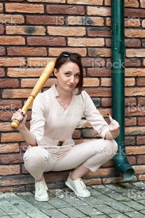 야구 방망이와 어린 소녀 섹스 제스처를 표시 하 고 벽돌 벽에 의해 다시 거리에 포즈 갈색에 대한 스톡 사진 및 기타 이미지
