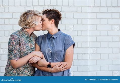 jeune position lesbienne aimante de couples en dehors de partager un baiser image stock image