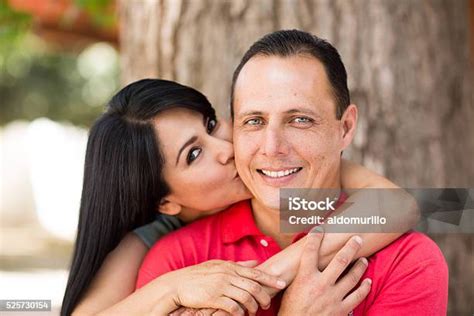 Beautiful Mature Latin Woman Kissing Cheek Of Handsome Latin Man Stock