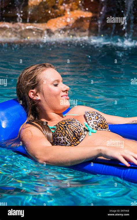 Young woman in bikini détente sur un flotteur dans la piscine femme de
