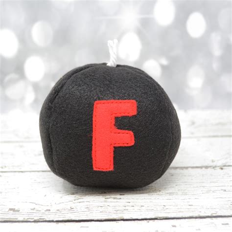 A Black And Red Felt Ball With The Letter F On It