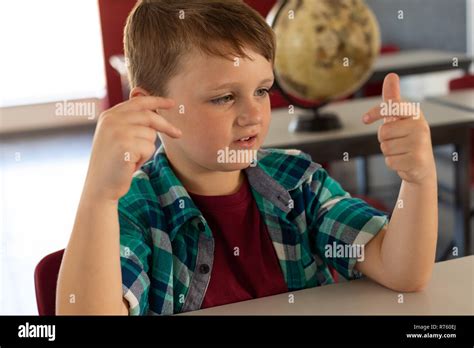 Boy Counting With His Finger At Desk In A Classroom Stock Photo Alamy