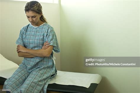 Female Patient Sitting On Examination Table Waiting For Doctor High Res