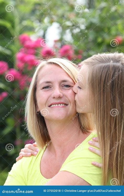 Happy Mother Being Kissed By Her Daughter Stock Photo Image Of