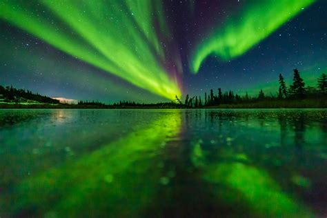 Aurora Reflecting On A Frozen Lake Near Yellowknife Northwest