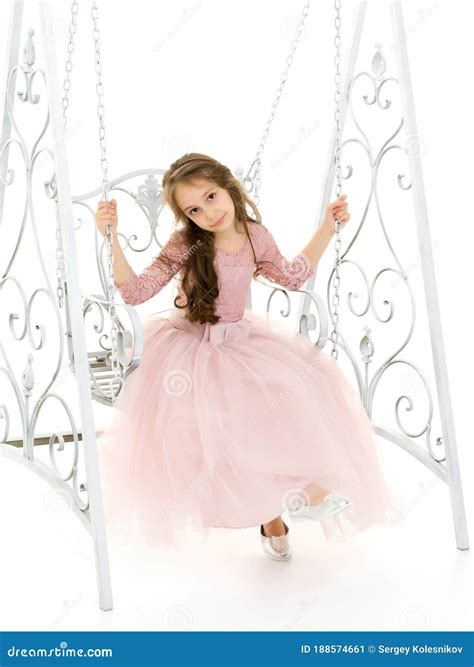 Charming Long Haired Girl In Nice Dress Swinging On Elegant Swing Stock