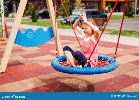 A Teenage Girl In A Summer Dress Plays On The Playground Near Her Home