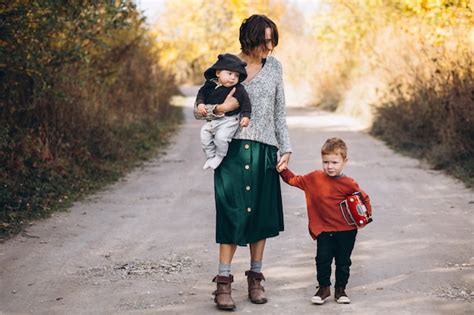 Joven Madre Con Dos Hijos Caminando En El Parque Foto Gratis