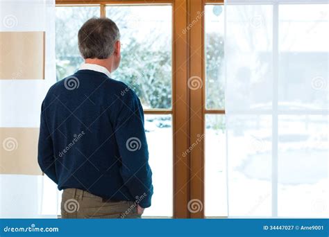 Senior Man Standing At The Window Looking Out Royalty Free Stock