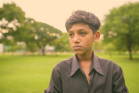 Portrait Of Young Indian Boy Relaxing At The Park Stock Photo Image