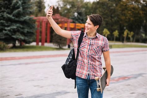 Adolescente Con Patineta Tomando Selfie Foto Gratis