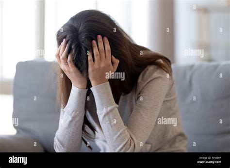 Depressed Young Woman Holding Head In Hands Feeling Hurt Upset Stock