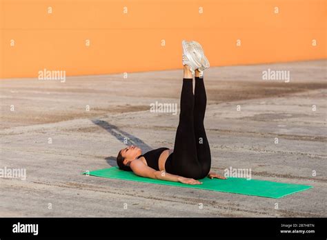 Fit Slim Young Woman In Tight Sportswear Black Pants And Top Lying On
