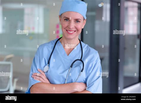 Portrait Of Smiling Caucasian Female Doctor Wearing Scrubs And