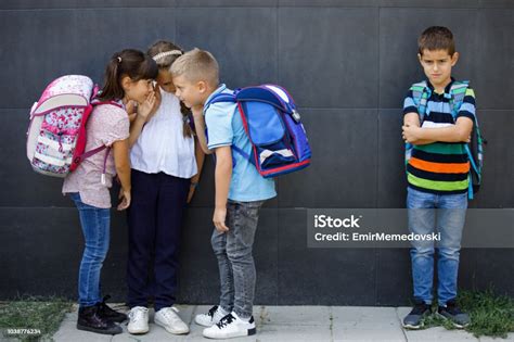 Unhappy Boy Being Gossiped About By School Friends Stock Photo
