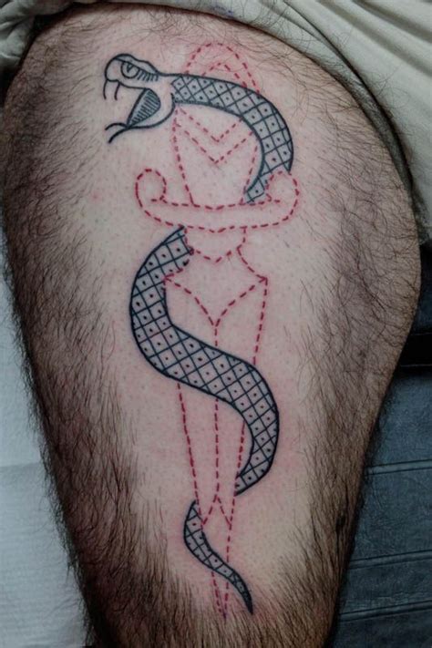 A Man With A Snake Tattoo On His Leg And The Words Initials Are In Red