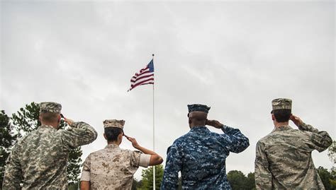 Soldiers Saluting The Flag