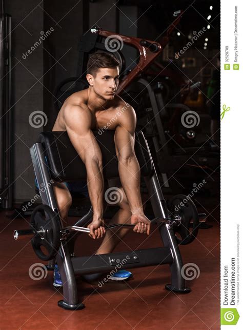 Muscular Man Working Out In Gym Doing Exercises With Barbell Stock