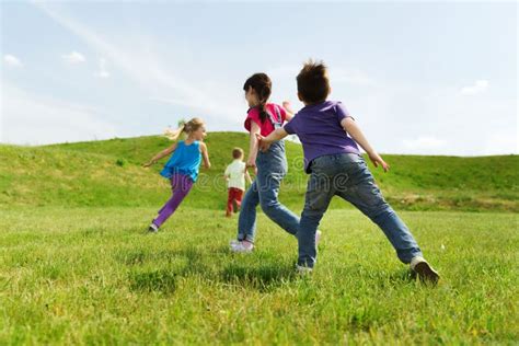 Grupo De Niños Felices Que Corren Al Aire Libre Imagen De Archivo