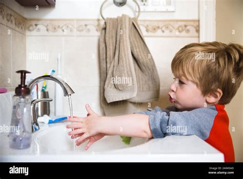 Ein Kleiner Junge Wäscht Seine Hände In Das Waschbecken Im Bad