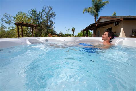 A Man Is Relaxing In The Jacuzzi At His Home On A Sunny Day