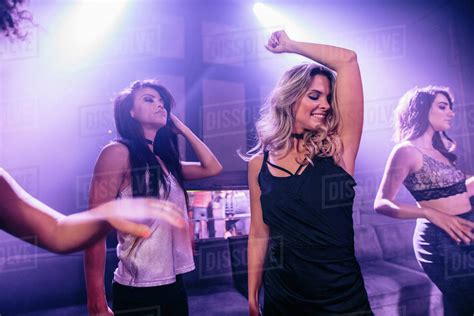Group Of Young People Dancing And Enjoying A Party In Nightclub Girls