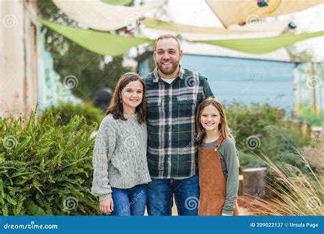 Un Padrastro Con Sus Hijas De Dos Escalones Paradas Afuera En Un Parque
