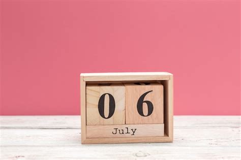 Premium Photo Wooden Cube Shape Calendar For July 6 On Wooden Tabletop