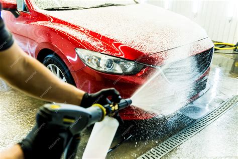 Premium Photo Worker Washing Car With Active Foam On A Car Wash