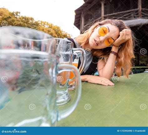 Drunk Asian Girl With Hangover Sleeping In Biergarten With Empty Beer Mugs Coloso