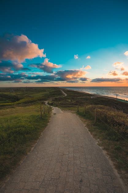 Free Photo Vertical Shot Of A Paved Pathway By The Sea Under The