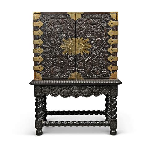 A BATAVIAN BRASS-MOUNTED EBONY, EBONISED AND SANDALWOOD CABINET-ON