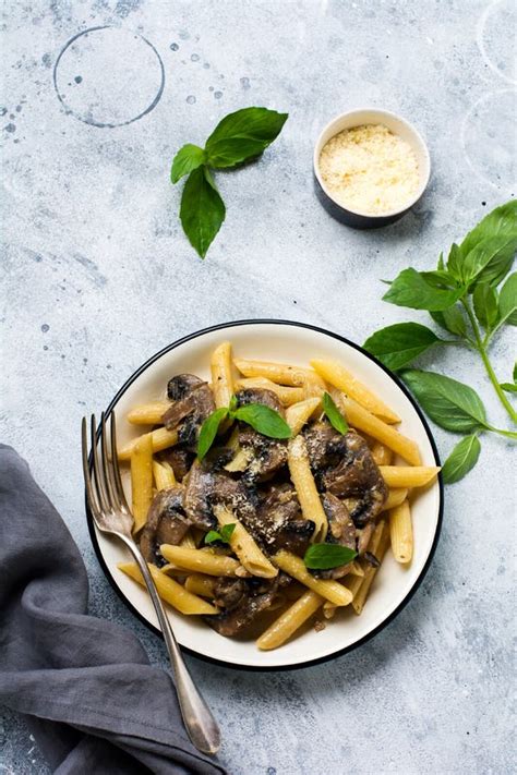 Penne Rigate Pasta With Mushrooms Parmesan Cheese And Basil Leaves In