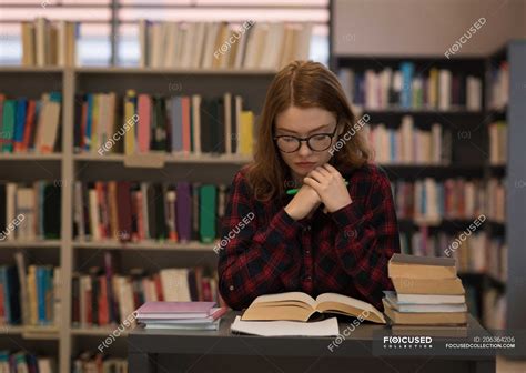 Young Woman Reading A Book In The Library — Hobby Paper Stock Photo