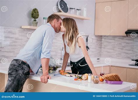 Romantic Couple Kissing When Prepare Cooking In The Kitchen Stock Photo