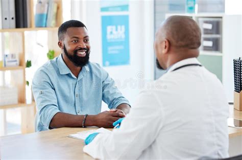 Young Man In Consult With His Doctor African Man Talking His Gp In A