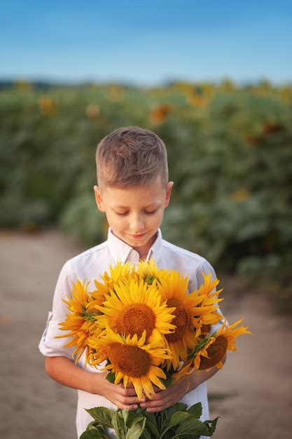 Premium Photo Happy Child With Bouquet Of Beautiful Sunflowers In